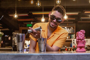 Latin Barman preparing alcoholic cocktail 