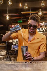 Latin Barman preparing alcoholic cocktail 