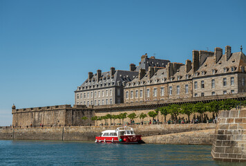 St. Malo, Brittany, France - July 8, 2022: Small red ferry docked at Quai de Dinan with Bastion...