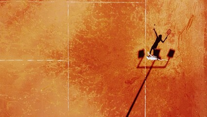 Tennis court drone aerial shot vertical top view, overhead shot of a player shadow silhouette  tennis player on a juicy red coating