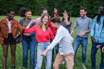 Group of young people of different nationalities dancing and having a fun time together outdoors