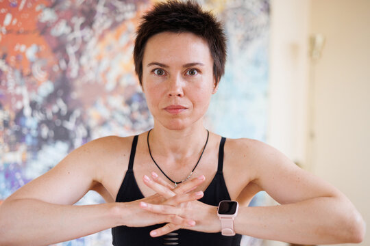 Young pretty yoga girl portrait. Beautiful short-haired woman doing pilates exercises. Woman in sports suit meditating. Beautiful woman smiling, flexible and slim.