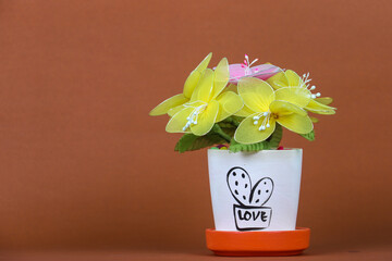 fake flowers in a vase on the table with copy space for design.