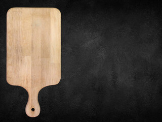 Brown scratched wooden cutting, choping board on dark background.