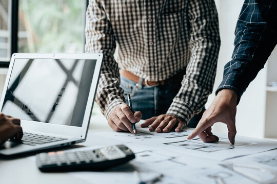 Close up of hands working brainstorming and measuring for cost estimating on paperworks and floor plan drawings about design architectural and engineering for houses and buildings.