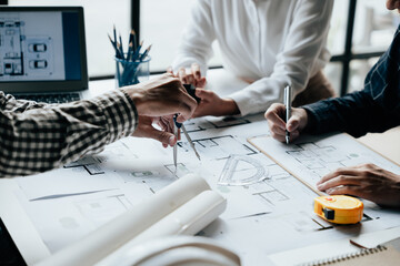 Close up of hands working brainstorming and measuring for cost estimating on paperworks and floor...