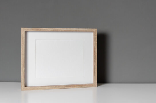 Landscape wooden frame mockup over grey wall interior