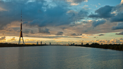Fototapeta na wymiar Riga, in the photo panorama of the city in the evening clouds and blue sky in the background, river in the foreground