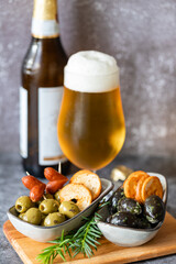 Delicious Italian appetizer for a glass of beer, green and black olives with herbs in olive oil