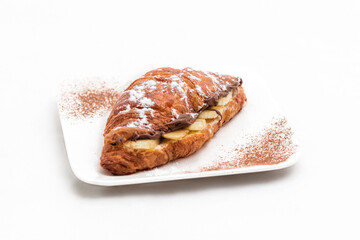 Croissant with chocolate butter and banana isolated on a white background. Horizontal photo