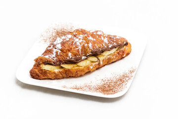 Croissant with chocolate butter and banana isolated on a white background. Horizontal photo
