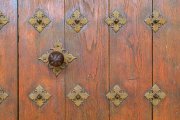 Ornate ironwork on the wooden gate of Santa Maria la Real church in Olite, Spain