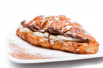 Croissant with chocolate butter and banana isolated on a white background.