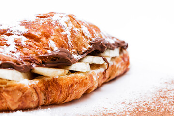 Croissant with chocolate butter and banana isolated on a white background.