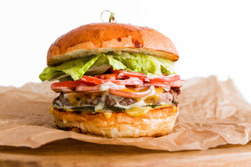 Craft beef burger on wooden plate isolated on white background.