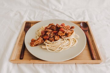 Homemade Beef Spaghetti with sauce served on white dish.