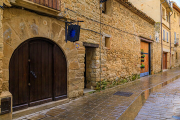 Old wooden gate with metal accents in an old stone house facade in Olite, Spain