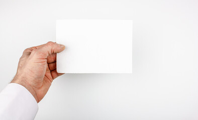 A man in a white shirt holds a blank blank on an isolated background. Blank, flyer, businessman or doctor holds in his hand.