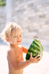 Little girl holding half a watermelon in her hands. High quality photo