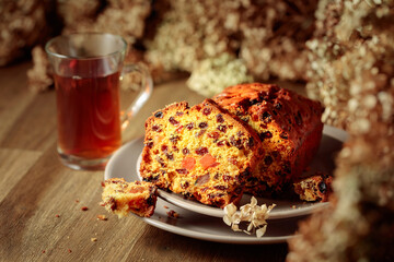  Fruit cake and tea on a wooden table with dried flowers.