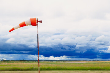 Horizontally flying windsock or wind vane against stormy sky