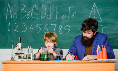 Happy teachers day. Knowledge day. Basic level chemistry knowledge. Study chemistry and biology. Congratulations September 1 holiday. School knowledge. Teacher bearded man and boy chemical laboratory