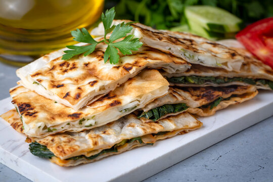 Fototapeta Traditional Turkish food, Turkish pancake gozleme with cheese and herb. The appetizer is Turkish pastry. There are varieties such as cheese, spinach, potato