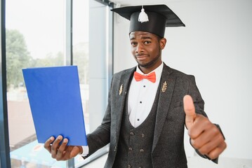 African American graduate holding diploma.