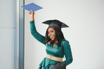 Happy Indian university student in graduation gown and cap.