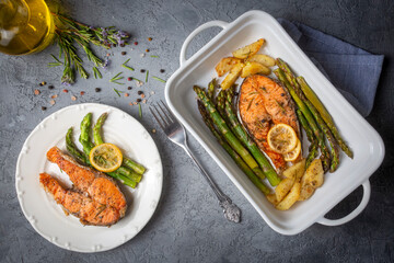 Grilled, baked salmon served on a plate with asparagus and potatoes.
