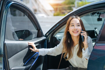 Asian business woman gets out of car and holding phone and coffee cup, right-hand drive, left-hand traffic, business lady, white business class luxury
