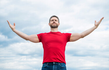 Fototapeta na wymiar proud man in red shirt outdoor on sky background