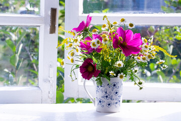 Bouquet of flowers of window sill in countryside

