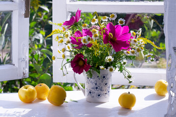Bouquet of flowers of window sill in countryside