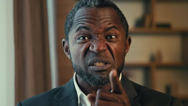 Portrait angry strict african american man expresses annoyance dissatisfaction shakes finger gesture disapproval sign prohibition talking scolds annoyed businessman looks at camera threatens scolding