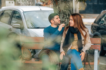romantic couple sitting in the park in autumn