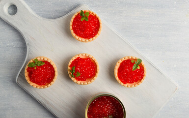 Tartlets with red caviar, on a light background, close-up, top view, no people,