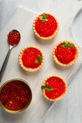 Tartlets with red caviar, on a light background, close-up, top view, no people,