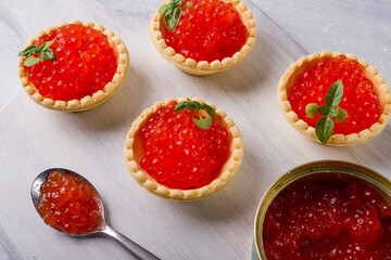 Fototapeta na wymiar Tartlets with red caviar, on a light background, close-up, top view, no people,