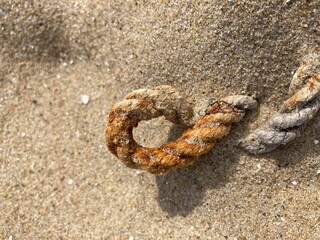 An eyelet of a rope in the sand on the beach