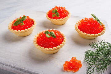 Tartlets with red caviar, on a light background, close-up, top view, no people,