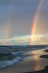 Kolorowa tęcza w czasie deszczu nad horyzontem morza. 