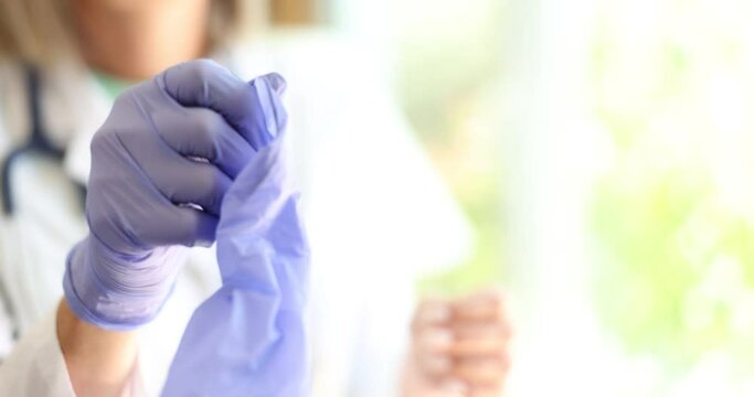 Doctor takes off medical gloves in lab coat