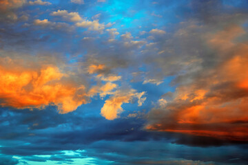 Obraz premium Fantastically beautiful clouds at sunrise in orange-blue tones, background for design