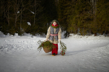 Nice cute teenager girl in old peasant clothes with hot fur coat and shawl in cold winter forest...