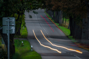 Color light lines in tree alley in dark summer evening near Roprachtice