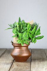 Fresh herb bouquet with rosemary, thyme, mint, sage and different kind of basil on jar. Farm-to market herbs and sprigs tied with string in a bouquet on wooden background.