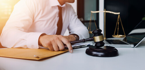Male lawyer working with contract papers and wooden gavel on tabel in courtroom. justice and law ,attorney, court judge, concept.