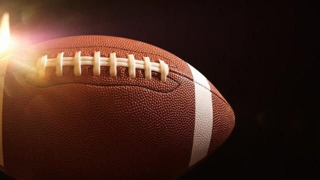 American Foot Ball Rotating In Dark Stadium Back-lighting, Cinematic 4k.