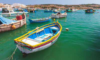 Small colorful Maltese fishing boats moored in Marsaxlokk